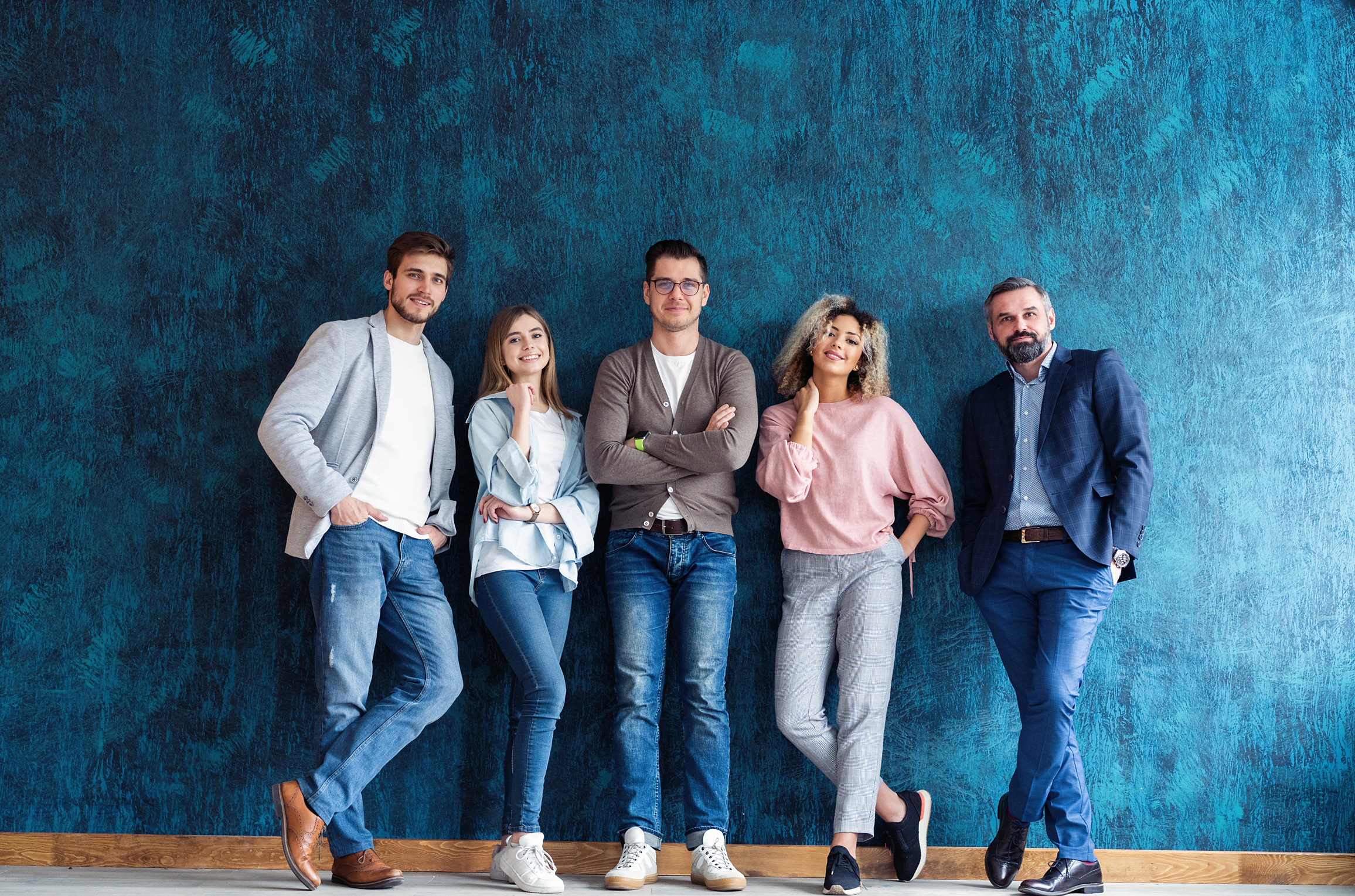 Portrait of creative business team standing together and laughing. Multiracial business people together at startup